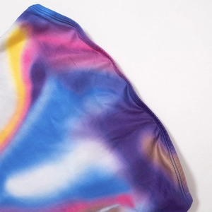 Close-up van kleurrijke tie-dye stof met fijne stiksels op de mouwloze korte jurk