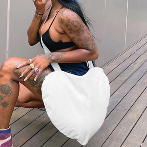 Vue latérale d'un grand sac à bandoulière blanc en forme de cœur avec une large sangle