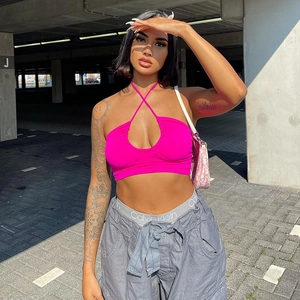 Hot pink halter neck crop top with crossover design and front cutout in streetwear style