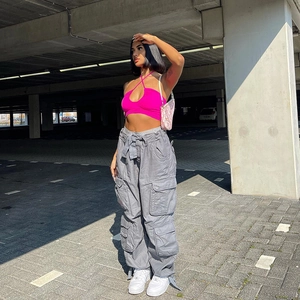 Women's streetwear look with grey multi-pocket cargo pants and pink halter neck crop top