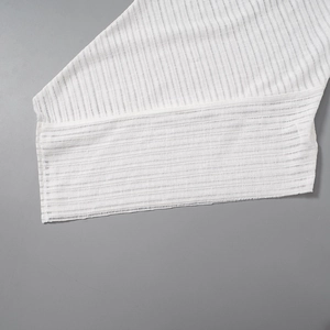 Close-up of white vertical ribbed fabric texture showing lightweight sheer material