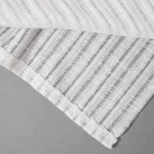 Macro shot of white ribbed knit fabric with sheer vertical hollow stripes and fine stitching