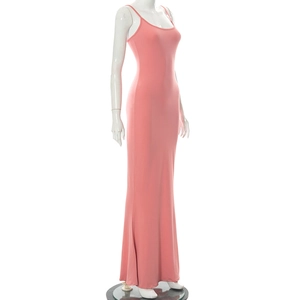 Détail d'une robe longue moulante sans manches rose pêche en tricot élastique