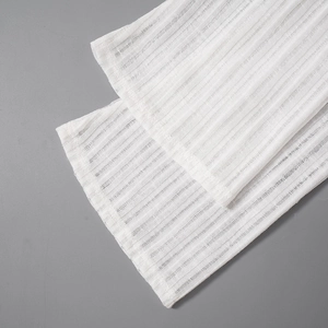 Detail of white ribbed knit sleeve showing vertical texture and semi-transparent fabric