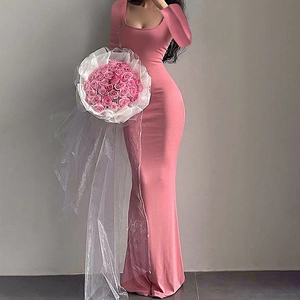 Détail d'une robe longue moulante rose avec décolleté carré et ourlet élégant en queue de poisson