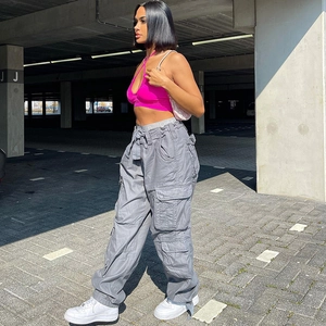 Detail of fuchsia halter crop top paired with grey multi-pocket cargo pants and sneakers