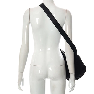 Détail du sac bandoulière en nylon noir en forme de croissant avec large sangle et zip