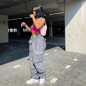 Close-up of dark grey cargo pants with side flap pockets and wide leg street style fit