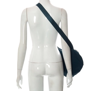 Détail d'un grand sac bandoulière en nylon bleu marine porté pour montrer la taille