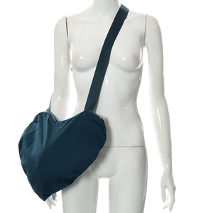 Détail d'un sac bandoulière en forme de cœur bleu marine sur un mannequin d'étalage