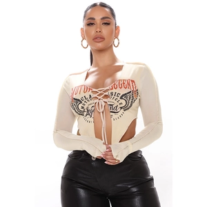 Dettaglio del crop top a maniche lunghe con stampa vintage e lacci frontali regolabili