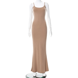 Gros plan d'une robe maxi moulante beige montrant la texture et les fines bretelles