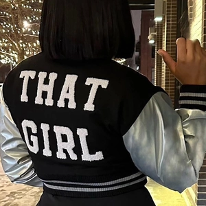 Nahaufnahme der Rückseite einer schwarzen PU-Leder Varsity-Jacke mit That Girl Bestickung