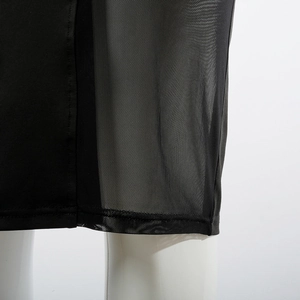 Detail view of the black mesh splicing hem and stitching quality on the dress