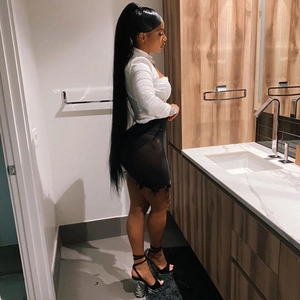 Detail view of extra long black straight ponytail extension reaching the thighs