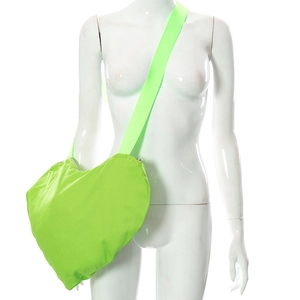 Sac bandoulière en forme de cœur vert néon avec large sangle porté sur un mannequin blanc