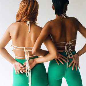 Detail of cross-straps backless halter top design on models with diverse skin tones