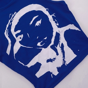 Λεπτομέρεια του royal blue crop top με μεγάλη λευκή καλλιτεχνική εκτύπωση πορτρέτου