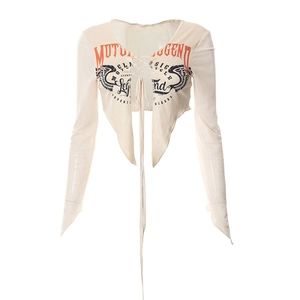 Dettaglio della stampa vintage e allacciatura sul crop top a maniche lunghe semitrasparente