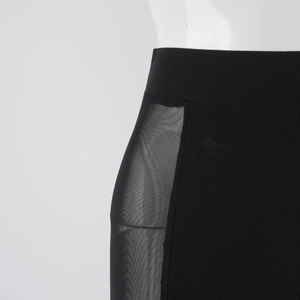 Detail of high-waisted black skirt featuring sheer mesh paneling and wide elastic waistband
