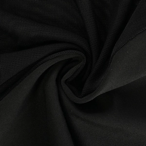Detail of black mesh patchwork and premium knit fabric texture on a mini skirt