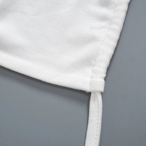 Close-up of white cotton fabric showing detailed stitching and tie-up strap details