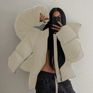 Detail of oversized beige puffer jacket with hood and smooth metallic zipper closure
