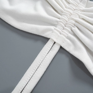 Close-up of white knitted fabric texture with fine straps and pleated detail craftsmanship