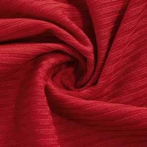 Detailed macro view of red ribbed knitted fabric texture with soft drapery and texture