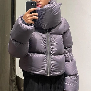Detail of a dark purple cropped puffer jacket with high wrap-around stand collar
