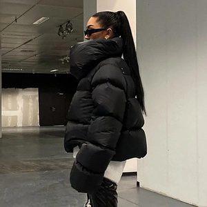 Close-up side view of a black oversized high-collar puffer jacket with shiny fabric