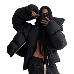 Women's oversized black puffer jacket with high collar and bold puffy sleeves in street style