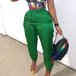 Close-up of vibrant green high-waist quilted joggers with drawstring and diamond pattern