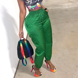 Detail of green quilted high-waisted joggers with drawstring and ribbed cuffs