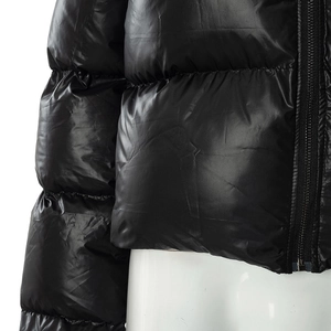 Detail of glossy black quilted puffer jacket with high-quality zipper and windproof fabric