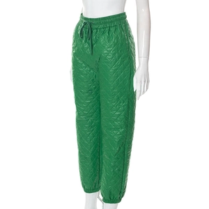 Detailed view of neon green quilted pants with elastic drawstring waist and ribbed cuffs