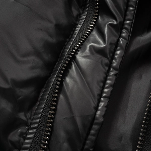 Close-up of durable metal zipper and waterproof nylon fabric on black winter puffer jacket
