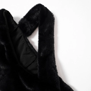 Detailed close-up of soft black faux fur texture and smooth fabric lining on the dress