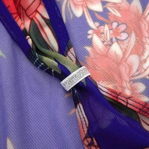 Detail van paarse mesh jurk met bloemenprint en zilveren glitter trekkoord accent