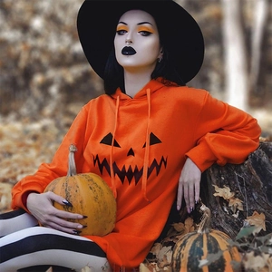 Dettaglio dell'abito con cappuccio arancione di Halloween con viso di zucca nero