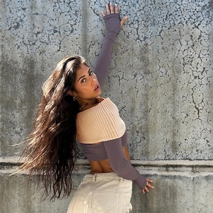 Detail of off-shoulder knitted crop top with contrast purple long sleeves and street style