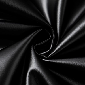 Macro shot of high-quality black faux leather fabric with smooth texture and subtle gloss