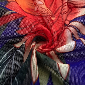 Detailopname van ademende mesh-stof met levendige tropische bloemenpatronen en texturen