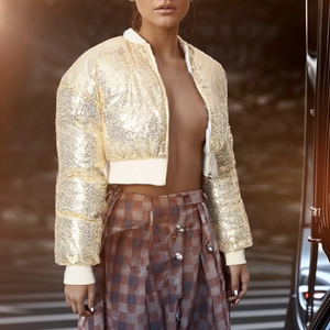 Detail of gold sequin bomber jacket featuring ribbed cuffs and metallic shimmer texture