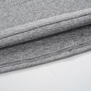 Gros plan détaillé montrant les coutures précises et le tricot gris doux de la robe