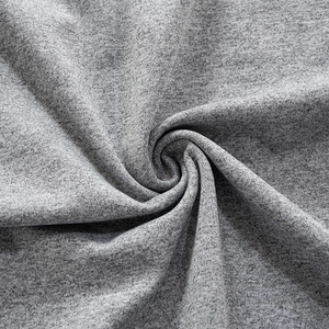 Gros plan sur un tricot gris chiné montrant une texture douce et un beau drapé