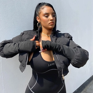 Detail of short black puffer jacket with metallic zipper and slim-fit jumpsuit logo