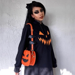 Dettaglio della stampa zucca Jack-o-lantern su felpa nera e borsa a tracolla zucca