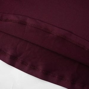 Gros plan détaillé montrant l'ourlet à double aiguille sur la robe en tricot bordeaux fin