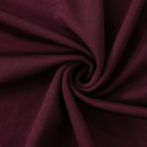 Gros plan sur la texture du tricot côtelé bordeaux avec un drapé souple et une finition lisse